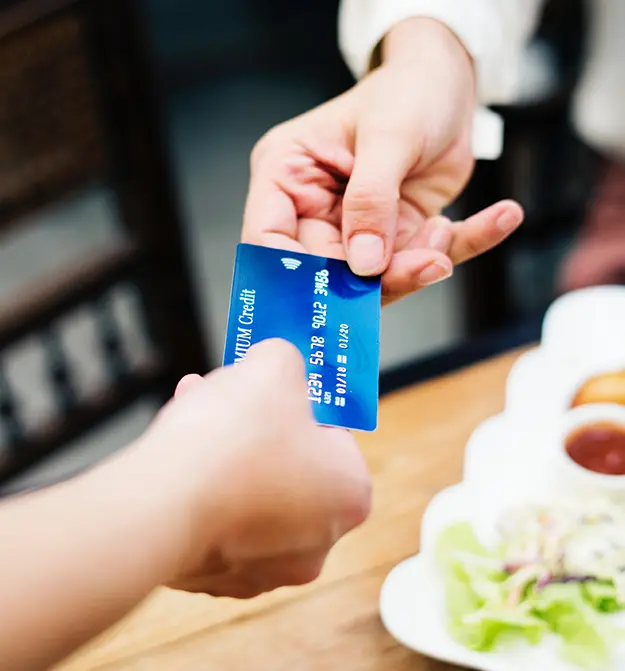 Credit card being exchanged between hands to make payment