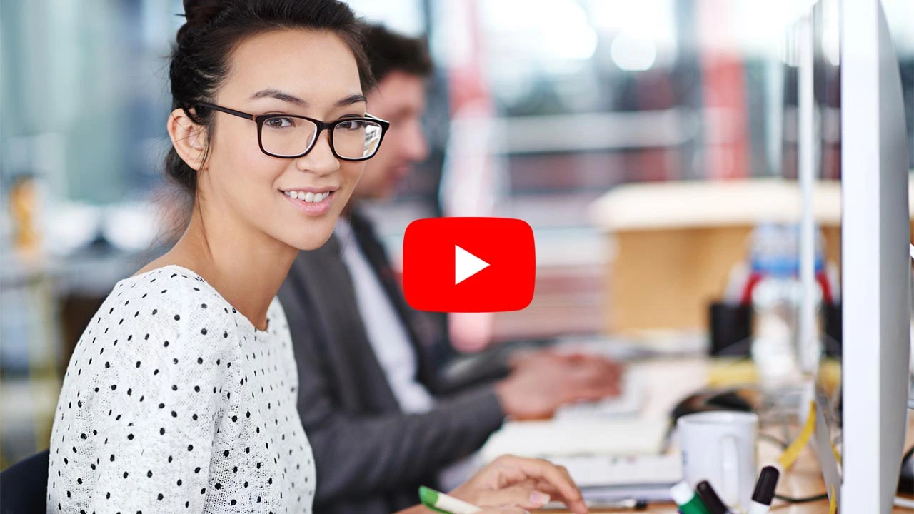 lady smiling at camera whilst working at a desk